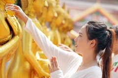 Tắm Phật là một trong những nghi lễ quan trọng và là một hoạt động không thể thiếu trong dịp Tết Bunpimay. (Ảnh: Đỗ Bá Thành/TTXVN)