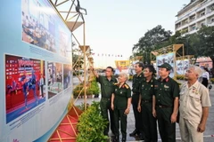 Các cựu chiến binh tham quan triển lãm. (Ảnh: Thu Hương/TTXVN)