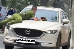 Hình ảnh vụ việc hất văng chiến sỹ Công an lên nắp capo xe ôtô. (Ảnh: TTXVN phát)