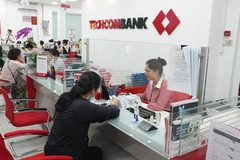 Khách hàng giao dịch tại Ngân hàng TechcomBank. (Ảnh: Thanh Tân/TTXVN)
