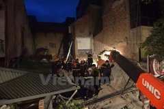 Lực lượng chức năng đang cứu hộ nạn nhân trong ngôi nhà 4 tầng tại 43 Cửa Bắc, Hà Nội. (Ảnh: Lê Minh Sơn/Vietnam+)