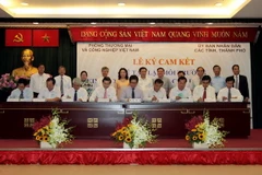 Chủ tịch Phòng Thương mại Công nghiệp Việt Nam Vũ Tiến Lộc cùng lãnh đạo UBND các tỉnh, thành phố ký cam kết. (Ảnh: Thanh Vũ/TTXVN)