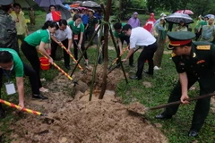 Các thủ khoa xuất sắc và đại biểu trồng tặng 100 cây xanh cho Đền Và. (Ảnh: Kim Chung/TTXVN)