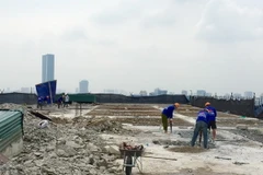 Công nhân Công ty Cổ phần Tập đoàn Phương Bắc dùng máy khoan phá dỡ phần trần bêtông. (Ảnh: Minh Nghĩa/TTXVN)