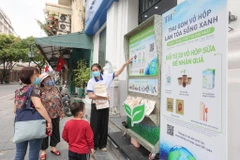 Nhân viên cửa hàng TH true mart tại số 6 Tràng Tiền chia sẻ với khách về chương trình. (Ảnh: Minh Sơn/Vietnam+)