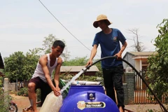 Người dân xã Ea Nuôi, huyện Buôn Đôn phải đi xin nước về phục vụ cho sinh hoạt. (Ảnh: Tuấn Anh/TTXVN)