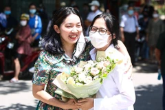 Một phụ huynh tặng hoa chúc mừng con gái hoàn thành tốt bài thi môn tổ hợp. (Ảnh: Phúc Tá/Vietnam+)