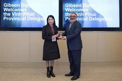 Bà Hoàng Thị Thúy Lan, Ủy viên Trung ương Đảng, Bí thư Tỉnh ủy Vĩnh Phúc (trái), trao tặng phẩm cho ông Emad H. Khalil, Giám đốc Công ty luật Gibson, Dunn & Crutcher. (Ảnh: Quang Huy - Phóng viên TTXVN tại Mỹ) 