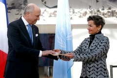 Bộ trưởng Ngoại giao Pháp Laurent Fabius trao tượng trưng chìa khóa cho bà Christiana Figueres, Thư ký điều hành của Công ước khung LHQ về biến đổi khí hậu.(Nguồn: AFP)