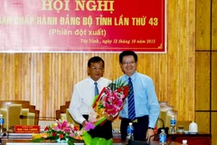 Ông Mai Văn Chính, Ủy viên Trung ương Đảng, Phó trưởng Ban Tổ chức Trung ương (phải) tặng hoa chúc mừng ông Phạm Văn Tân. (Ảnh: Thanh Tân/TTXVN)