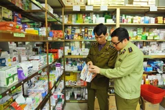 Cán bộ Đội QLTT thành phố Ninh Bình kiểm tra mặt hàng khẩu trang. (Ảnh: Minh Đức/TTXVN)