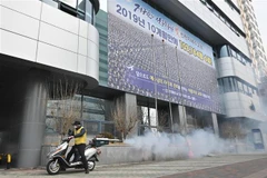 Nhân viên y tế phun thuốc khử trùng phía trước nhà thờ của giáo phái Tân Thiên Địa ở thành phố Daegu, Hàn Quốc ngày 21/2/2020. (Ảnh: AFP/TTXVN)