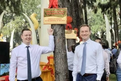 Các cán bộ Tổng lãnh sự Belarus tại Thành phố Hồ Chí Minh bên cây thông gắn bảng tên Tổng Lãnh sự quán Belarus tại Vườn thông Hữu nghị. (Ảnh: Xuân Khu/TTXVN)