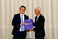 Phó Chủ tịch Ủy ban Nhân dân Thành phố Hồ Chí Minh Võ Văn Hoan (phải) tặng sách đối ngoại cho Thượng nghị sỹ Joseph Nguyen. (Ảnh: Xuân Khu/TTXVN)