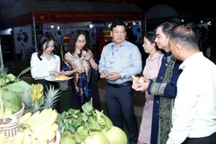 Các quan khách và người dân địa phương ăn thử các loại hoa quả do một doanh nghiệp Việt Nam trồng tại khu vực Tam giác Phát triển CLV. (Ảnh: Phạm Kiên/TTXVN)
