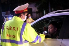 Lực lượng Công an tỉnh Hưng Yên kiểm tra nồng độ cồn với người điều khiển phương tiện giao thông. (Ảnh: Đinh Văn Nhiều/TTXVN)