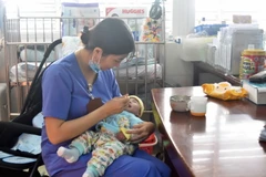 Hơn 1 năm nay, em bé sinh non nhiều bệnh tật bị bỏ rơi tại Khoa Hồi sức Cấp cứu Nhi và Nhi sơ sinh được các y, bác sỹ chữa bệnh, nuôi dưỡng và xem là con trai của khoa. (Ảnh: Nguyên Dung/TTXVN)