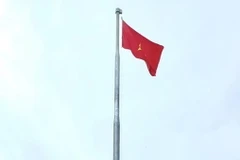 Cán bộ và lực lượng vũ trang bên cột cờ Tổ quốc vừa khánh thành trên đảo Thanh Lân, Cô Tô, Quảng Ninh. (Ảnh: TTXVN phát)