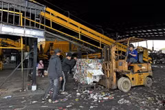 Một số công nhân của nhà máy dọn dẹp phế phẩm phụ của rác thải sau khi dây chuyền xử lý rác ngừng hoạt động. (Ảnh: Nguyễn Dũng/TTXVN)