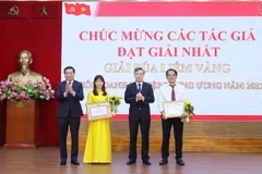 Phó Trưởng Ban Tổ chức Trung ương Nguyễn Quang Dương và Bí thư Đảng ủy Khối Doanh nghiệp Trung ương Nguyễn Long Hải trao giải Nhất cho các tác giả đoạt giải. (Ảnh: An Đăng/TTXVN)