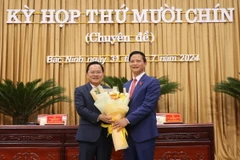 Bí thư Tỉnh ủy Bắc Ninh Nguyễn Anh Tuấn (bên trái) tặng hoa chúc mừng Chủ tịch Ủy ban Nhân dân tỉnh khóa XIX, nhiệm kỳ 2021-2026 Vương Quốc Tuấn. (Ảnh: Thái Hùng/TTXVN)