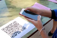 Khách hàng nên đối chiếu thông tin số tài khoản, tên chủ tài khoản với chủ cửa hàng sau khi quét QR thanh toán. (Ảnh minh họa. Nguồn: TTXVN)