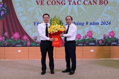 Phó Bí thư Thường trực Tỉnh ủy Tạ Văn Long trao Quyết định và tặng hoa chúc mừng tân Chánh Văn phòng Tỉnh ủy An Hoàng Linh. (Ảnh: Tuấn Anh/TTXVN)