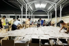 Lực lượng chức năng thu giữ hàng nghìn bao thuốc lá nhập lậu. (Ảnh: TTXVN phát)