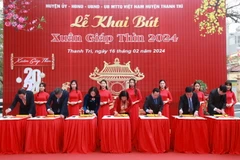 Các đại biểu thành phố Hà Nội thực hiện nghi thức khai bút. (Ảnh: TTXVN phát)