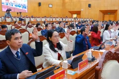 Các đại biểu biểu quyết thông qua 9 Nghị quyết tại kỳ họp. (Ảnh: Quân Trang/TTXVN)