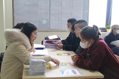 Giới thiệu các chế độ, chính sách với người lao động. (Ảnh: Đồng Thúy/TTXVN)