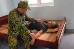 Cán bộ y tế Đồn Biên phòng thăm khám cho ngư dân gặp nạn. (Ảnh: TTXVN phát)