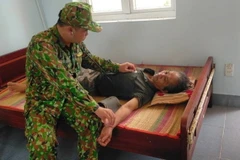 Cán bộ y tế Đồn Biên phòng thăm khám cho ngư dân gặp nạn. (Ảnh: TTXVN phát)