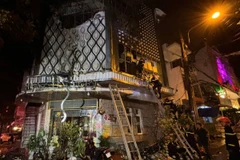 Lực lượng chức năng làm nhiệm vụ tại hiện trường vụ cháy. (Ảnh: Tuấn Anh/TTXVN)