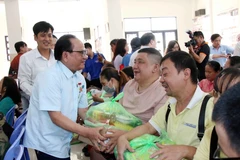 Ông Nguyễn Hữu Nhơn, Chánh Hội trưởng Nam Thành Thánh thất, trao quà Tết cho người nghèo, người có hoàn cảnh khó khăn trên địa bàn thành phố. (Ảnh: Xuân Khu/TTXVN)