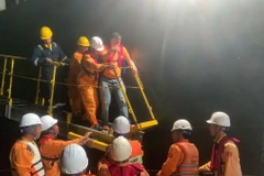 Tiếp nhận bệnh nhân từ tàu TYANA sang tàu SAR 272 để đưa vào bờ. (Ảnh: TTXVN phát)