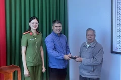 Cụ Phạm Xuân Tuệ trả lại tài sản cho người đánh rơi tại Công an phường 2. (Ảnh TTXVN phát)