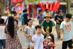 Dù nắng nóng nhưng người dân và du khách vẫn dạo bước, ngắm cảnh bên hồ. (Ảnh: Thanh Tùng/TTXVN)
