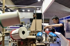 Doanh nghiệp giới thiệu máy móc, thiết bị mới tại Triển lãm. (Ảnh: Mỹ Phương/TTXVN)