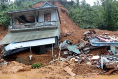 Hai căn nhà 2 tầng được xây kiên cố tại thôn Nà Thoi (xã Quang Thuận, huyện Bạch Thông, tỉnh Bắc Kạn) bị đất, đá từ taluy dương sạt lở, tàn phá. (Ảnh: Nguyễn Công Hải/TTXVN)