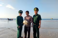 Cán bộ Đồn Biên phòng Phước Thuận tiếp nhận cá thể đồi mồi từ ngư dân Đỗ Xuân Ngọc. (Ảnh: TTXVN)
