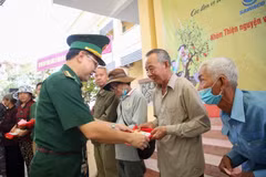 Đại tá Phạm Đình Triệu, Chính ủy Bộ đội Biên phòng Tây Ninh tặng quà cho người dân vùng biên giới. (Ảnh: Giang Phương/TTXVN)