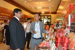 Đại biểu Ấn Độ tìm hiểu về sản phẩm càphê của tỉnh Đắk Lắk. (Ảnh: Tuấn Anh/TTXVN)