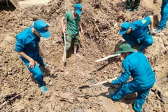 Tìm kiếm, quy tập hài cốt liệt sỹ. (Ảnh: TTXVN phát)