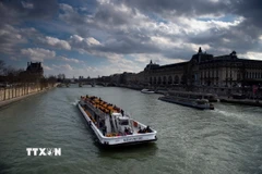 Các thuyền chở khách du lịch di chuyển trên sông Seine ở Paris, Pháp. (Ảnh: AFP/TTXVN)