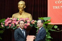 Ủy viên Trung ương Đảng, Bí thư Thành ủy Đà Nẵng Nguyễn Văn Quảng (phải) trao Quyết định của Ban Bí thư Trung ương Đảng chuẩn y ông Nguyễn Đình Vĩnh giữ chức Phó Bí thư Thành ủy Đà Nẵng. (Ảnh: Quốc Dũng/TTXVN)