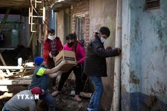 Tình nguyện viên phân phát lương thực cứu trợ do dịch COVID-19 cho người dân tại Buenos Aires, Argentina, ngày 25/7/2020. (Ảnh: AFP/TTXVN)