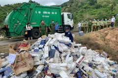 Tiêu hủy thuốc lá ngoại nhập lậu. (Ảnh: TTXVN phát)