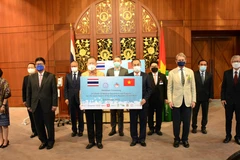 Đại sứ Việt Nam tại Thái Lan Phan Chí Thành (bên phải) tiếp nhận tượng trưng lô hàng vật tư y tế từ ông Sanan Angubolkul, Chủ tịch Hội Hữu nghị Thái Lan-Việt Nam. (Ảnh: TTXVN phát)