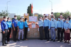 Bà Nguyễn Thị Trúc Mai (trái) tiếp nhận bảng tượng trưng cho số thực phẩm và vật tư y tế do Campuchia trao tặng. (Ảnh: Thanh Tân/TTXVN)